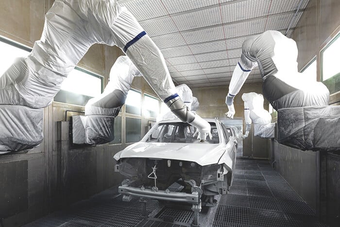industrial robots spray painting car body panels on an assembly line